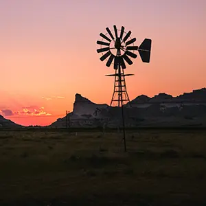 Nebraska windmill with bluffs in the background at sunset